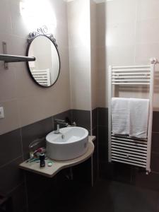 a bathroom with a sink and a mirror and towels at Sira House Milano in Milan