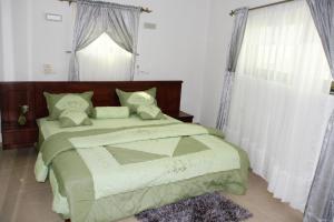 ein Schlafzimmer mit einem großen Bett und einem Fenster in der Unterkunft Amazing Grace Residence in Cotonou