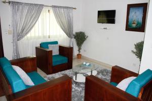 sala de estar con 2 sillas y TV en Amazing Grace Residence en Cotonú