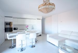 a white kitchen with a chandelier and a living room at Modern Apartment in Valencia in Valencia