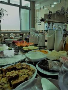 a kitchen counter with many plates of food on it at Pousada Terra Garrida in Maceió
