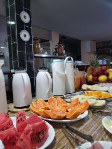 a table with plates of fruit and pitchers of milk at Pousada Terra Garrida in Maceió