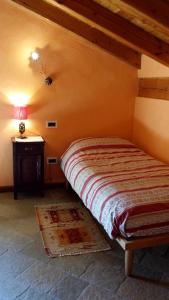 a small bedroom with a bed and a table at Il Rifugio della Volpe in Introd