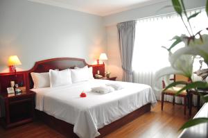 Un pat sau paturi într-o cameră la Kingdom Hotel
