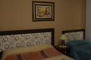 1 dormitorio con 1 cama y una foto en la pared en Apartamento Los Abuelos Calle Esteva Berga en Colón