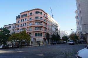 リスボンにあるAvenida Cozy Apartmentの都市通りの高いピンクの建物