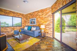 a living room with a blue couch and a brick wall at Aquila in Mount View