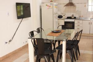 uma cozinha com uma mesa de vidro e cadeiras pretas em Apartamento Los Abuelos Calle Esteva Berga em Colón