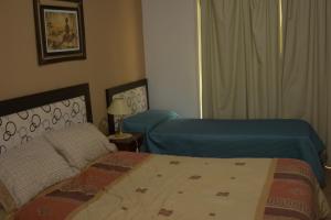 a hotel room with two beds and a window at Apartamento Los Abuelos Calle Esteva Berga in Colón