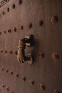 une porte métallique avec un paquet de bronze sur elle dans l'établissement Riad MALAÏKA, à Essaouira