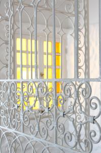 - une vue sur une porte traversant une porte en métal dans l'établissement Riad MALAÏKA, à Essaouira