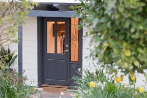 uma porta preta numa pequena casa em The Other House em Piccadilly