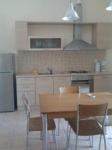 a kitchen with a wooden table and chairs in it at Studios Nikolaou Bros in Parga