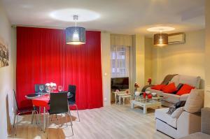 sala de estar con cortina roja y sofá en APARTAMENTO MURILLO EN EL PRADO, en Sevilla