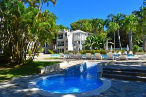 a resort pool with chairs and a fountain at Tropical Casa Laguna in Cabarete
