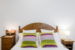 マドリードにあるCharming Retiroのベッドルーム1室(緑と紫の枕が備わるベッド1台付)