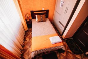 a small bedroom with a bed and a window at Las Tholas Hotel in Uyuni