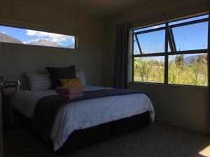 una camera da letto con un letto e una grande finestra di Franz Josef Villa a Franz Josef