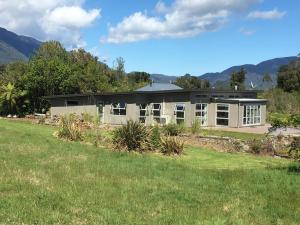 una casa su una collina con un prato di Franz Josef Villa a Franz Josef