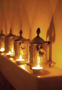 a row of lanterns with candles on a table at Riad MALAÏKA in Essaouira