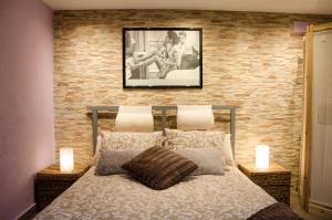 um quarto com uma cama com uma parede de tijolos em Apartment Vacarisses Torreblanca Estación, Piscina Privada em Vacarisas