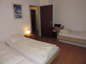 1 dormitorio con 2 camas, mesa y silla en Palousa (352 Br), en Valbella