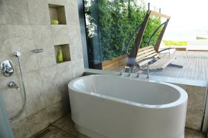 a bath tub in a bathroom with a patio at Ataköy Marina Park Hotel Residence in Istanbul
