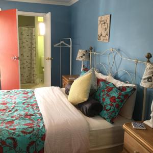a bedroom with a bed with blue walls at KI Dragonfly Guesthouse in Kingscote