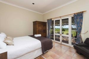 a bedroom with a bed and a large window at Holman Estate in Pokolbin