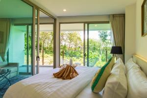 a bedroom with a large white bed with glass doors at Oceana Sea View Apartments - Kamala Beach in Kamala Beach +53 photos