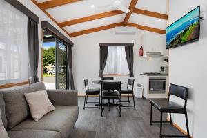 a living room with a couch and a table and chairs at Warrnambool Holiday Village in Warrnambool