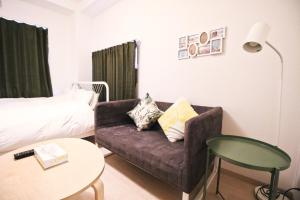 un salon avec un canapé et un lit dans l'établissement Uhome Kanda Hotel, à Tokyo