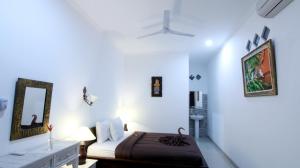 a bedroom with a bed and a mirror in a room at Ayye Bungalows in Ubud