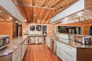 a large kitchen with white appliances and wooden ceilings at Milbrodale Lodge in Broke