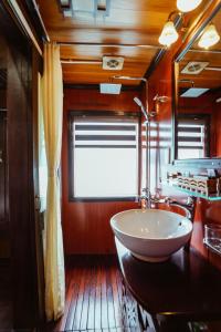a bathroom with a bowl sink on a wooden floor at Renea Cruises Halong in Ha Long