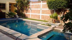 a swimming pool in front of a house at HOTEL POSADA MONTSERRAT in Temixco