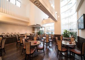 une salle à manger avec des tables et des chaises dans un restaurant dans l'établissement Hotel Claiton Esaka, à Suita