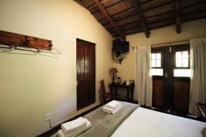 um quarto com uma cama com toalhas em The Old Orchard Guest House em Kokstad