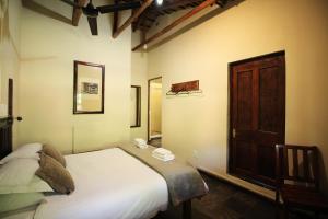 um quarto com uma cama e uma porta de madeira em The Old Orchard Guest House em Kokstad
