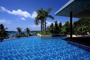 a swimming pool with a view of the ocean at The heights Kata seaview large condo in Kata Beach