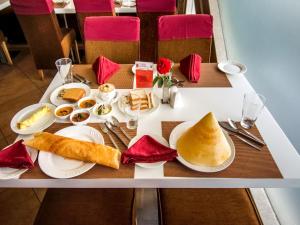 a table with plates of breakfast food on it at Hotel Rockdale in Visakhapatnam