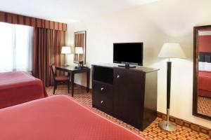 a hotel room with a bed and a flat screen tv at Super 8 by Wyndham Chicago Northlake O'Hare South in Northlake