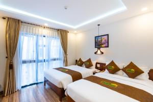 een hotelkamer met 2 bedden en een raam bij HODI Hotel in Da Nang