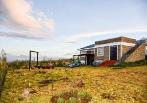 a brick house on a hill with a yard at Ole Munyak-4 bed house on the hill in Naivasha