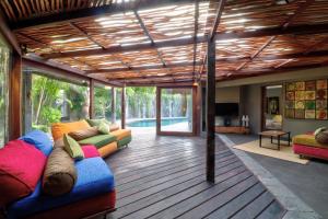 una sala de estar con muebles coloridos en el suelo de madera en Villa Sham, en Seminyak