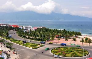 een luchtzicht op een straat met palmbomen en de oceaan bij HODI Hotel in Da Nang