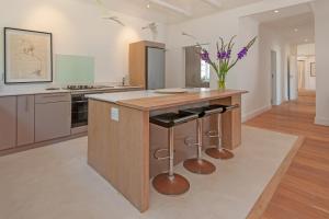 a kitchen with a wooden island with stools at K5 White House in Hermanus