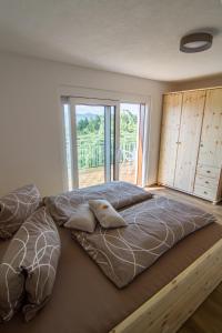 1 cama grande en un dormitorio con ventana grande en Ferienwohnung Traumaussicht en Leutschach