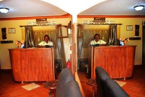 a man and a woman in front of mirrors at Eco Resort Kasenyi in Entebbe