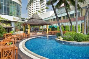 a patio with a pool, chairs, and tables in it at Prince Palace Hotel - SHA Extra Plus in Bangkok